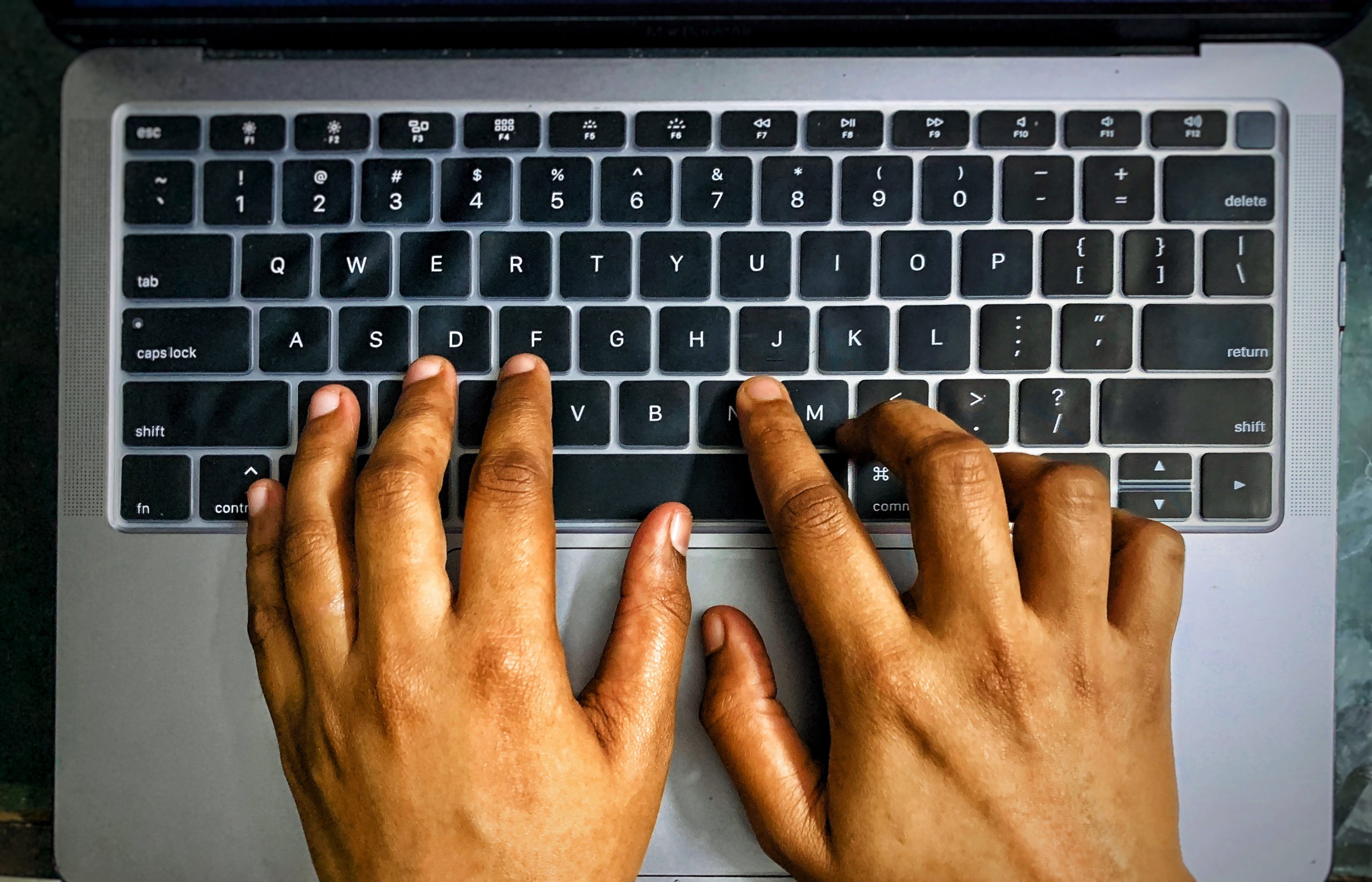 Person typing on laptop keyboard